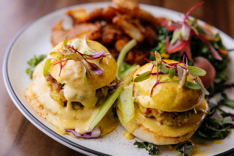 Crab Cake Benedict - Crab cake Benedict topped with hollandaise at Brekki Brekki, one of the best breakfast restaurants in Albuquerque on Comanche Road Northeast.