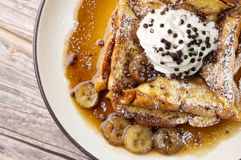Bananas Foster French Toast - Decadent French Toast topped with bananas at Brekki Brekki, your go-to for breakfast in Albuquerque, french toast, or crepes near me.